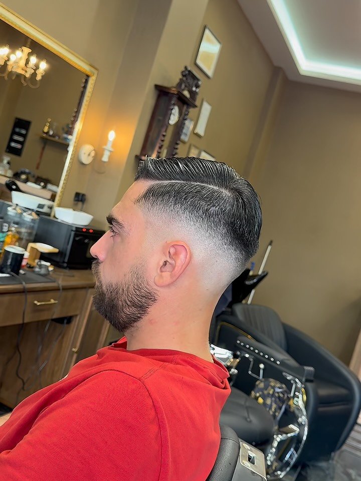 Ολοκληρωμένο κούρεμα σε προφίλ, με skin fade στο πλάι και τη γραμμή της χωρίστρας